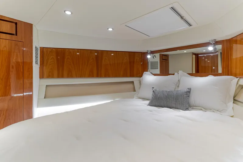 No Contingencies Yacht Photos Pics Luxurious bedroom interior of 2012 Riviera 44 Sport Yacht with wood paneling and plush bedding.