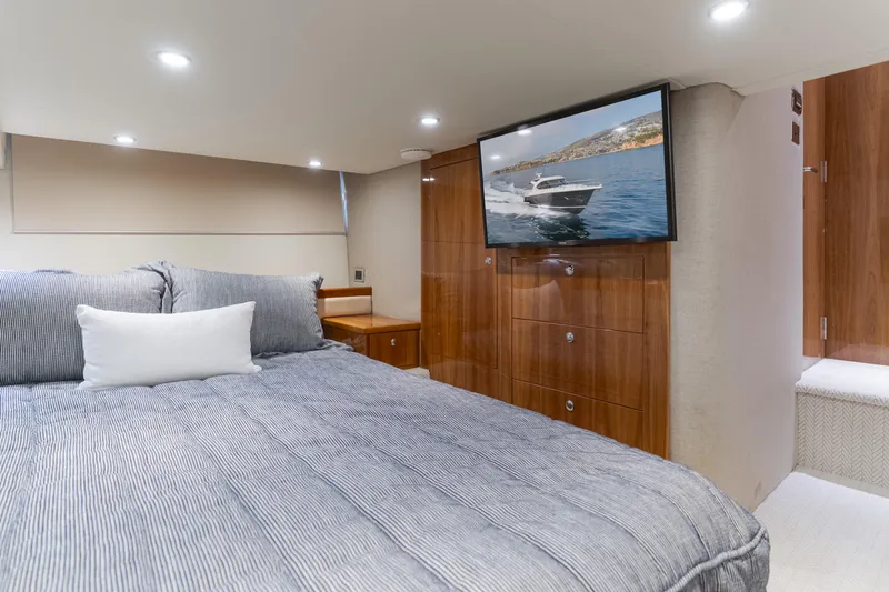 No Contingencies Yacht Photos Pics Luxurious bedroom interior of 2012 Riviera 44 Sport Yacht with TV and elegant wood finishes.