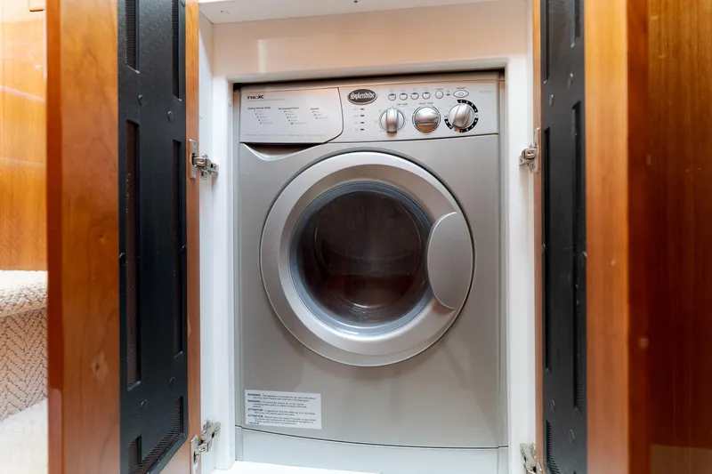 No Contingencies Yacht Photos Pics Washing machine inside 2012 Riviera 44 Sport Yacht, wooden cabinet doors open.