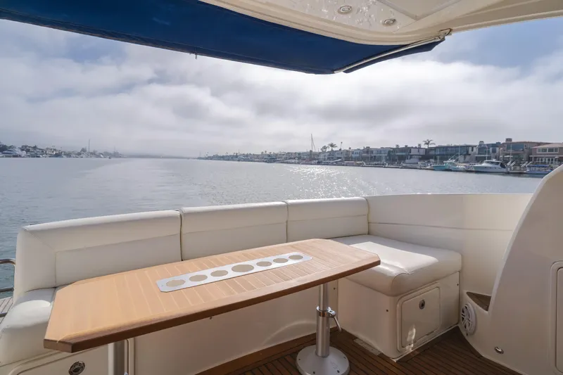 No Contingencies Yacht Photos Pics 2012 Riviera 44 Sport Yacht interior with waterfront view, featuring a sleek seating area and table.