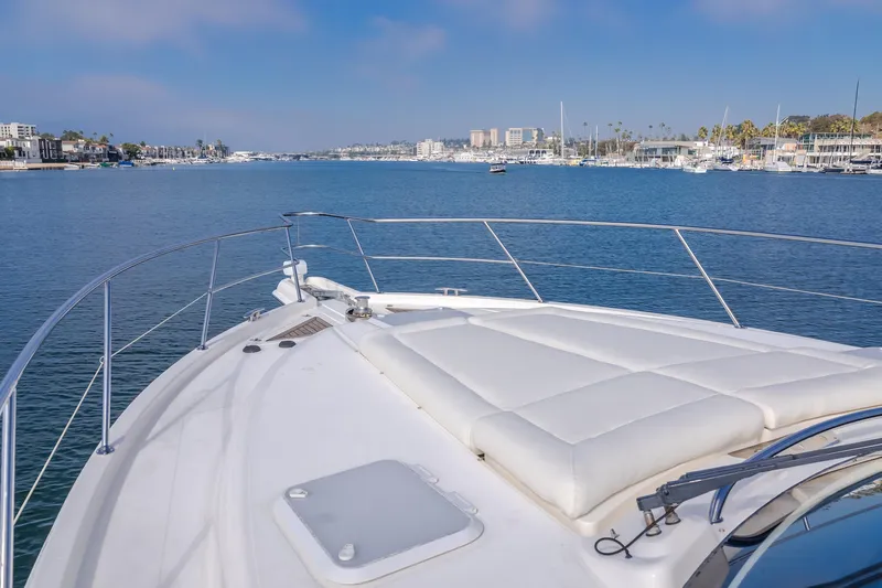 No Contingencies Yacht Photos Pics 2012 Riviera 44 Sport Yacht cruising in a scenic marina with clear blue skies.