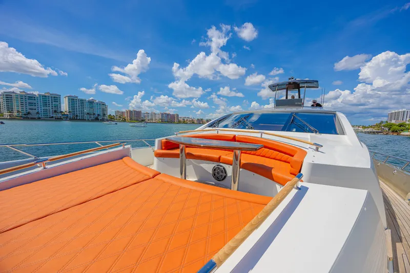  Yacht Photos Pics Luxurious 2010 Lazzara LSX 92 yacht with orange seating, cruising near waterfront buildings.