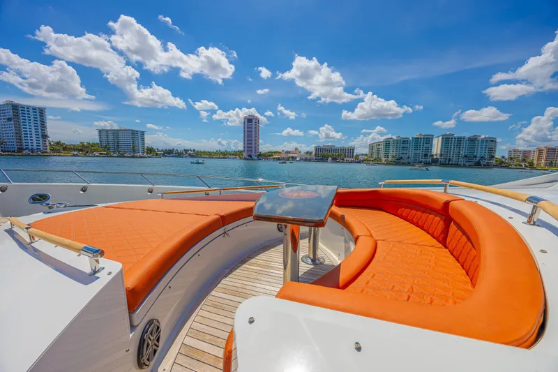  Yacht Photos Pics Luxurious 2010 Lazzara LSX 92 yacht with orange seating, city skyline, and blue sky.