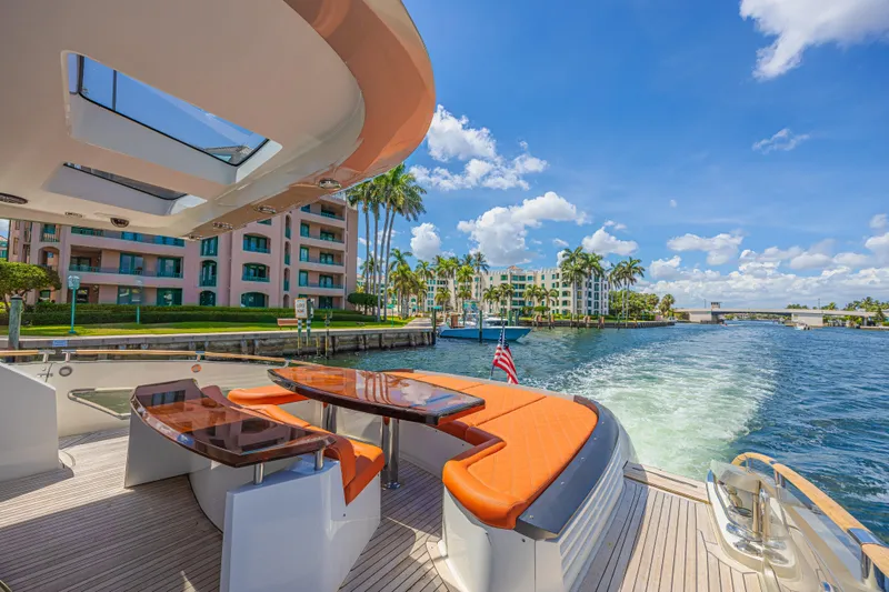  Yacht Photos Pics Luxurious 2010 Lazzara LSX 92 yacht cruising near waterfront buildings and palm trees.