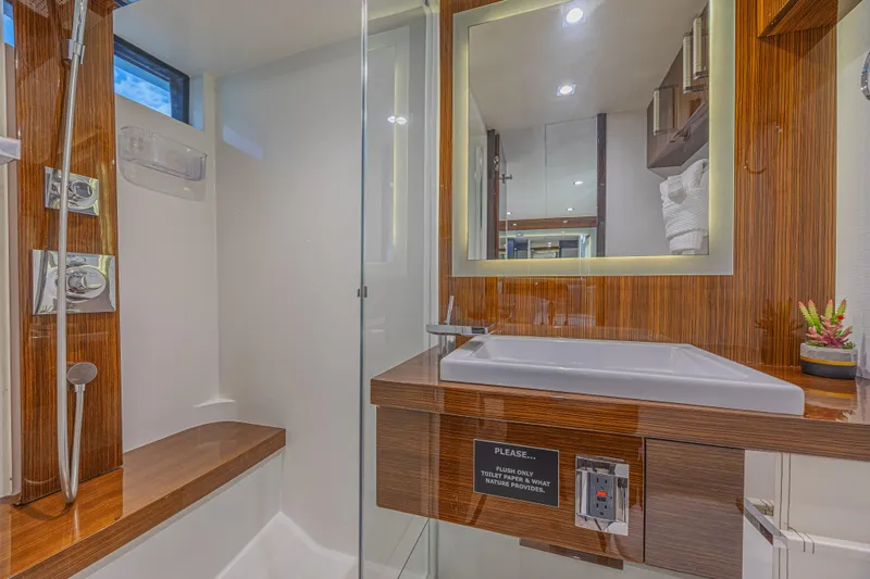  Yacht Photos Pics Luxurious bathroom in 2010 Lazzara LSX 92 yacht with modern fixtures and wood accents.
