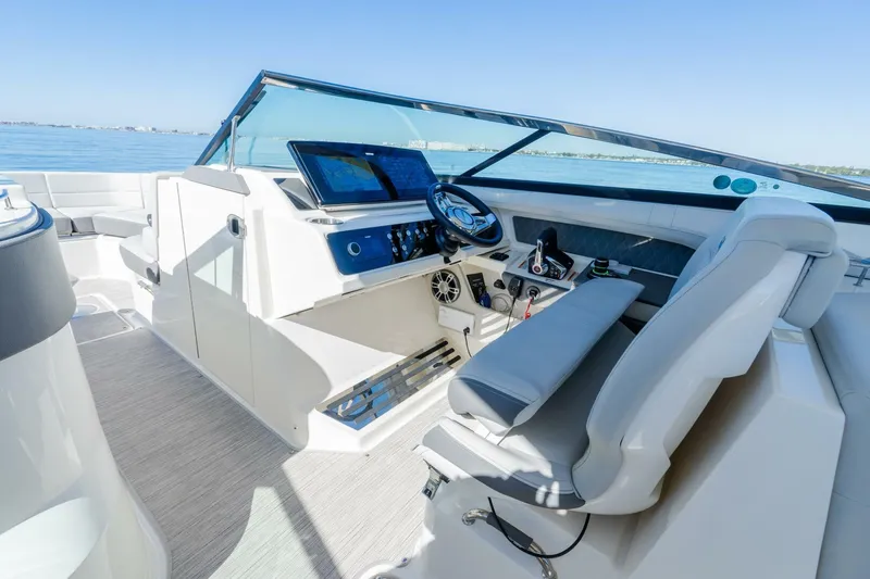  Yacht Photos Pics 2023 Sea Ray SLX 310 Outboard cockpit with modern controls and seating, overlooking calm waters.