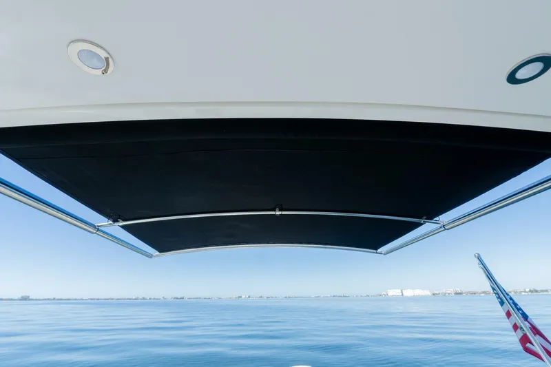  Yacht Photos Pics 2023 Sea Ray SLX 310 Outboard boat with canopy, overlooking calm ocean waters.