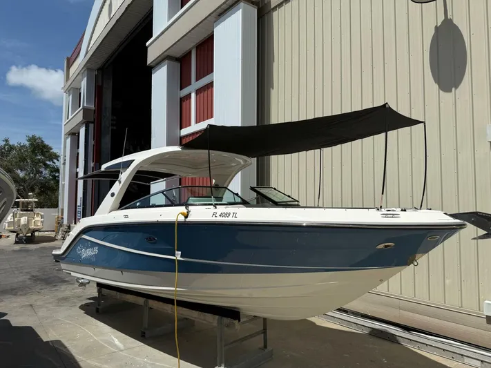  Yacht Photos Pics 2023 Sea Ray SLX 310 Outboard boat with blue hull, docked near a building.