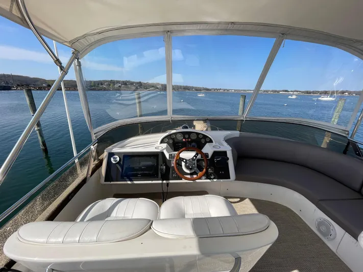  Yacht Photos Pics Flybridge of 2005 Viking Princess 50, featuring helm and seating, overlooking serene waters.