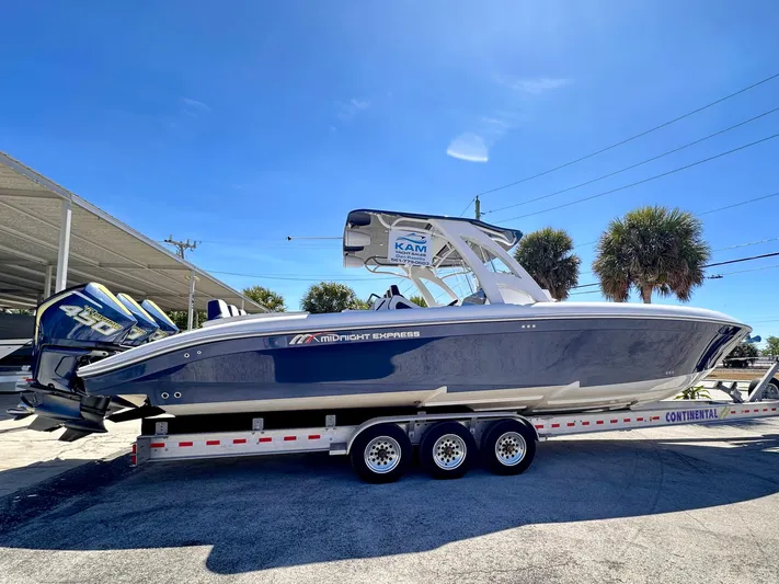  Yacht Photos Pics 2022 Midnight Express 37 Open boat on trailer, parked outdoors under clear sky.