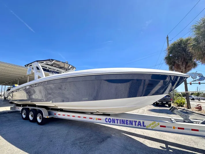  Yacht Photos Pics 2022 Midnight Express 37 Open boat on Continental trailer, parked outdoors under clear sky.