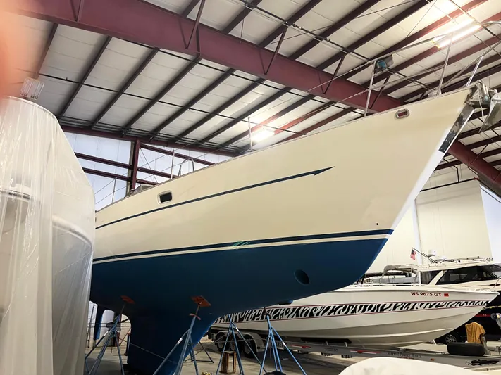 Here Be Dragons Yacht Photos Pics Oyster 46.5 sailboat from 1987 in a boatyard, elevated on stands.