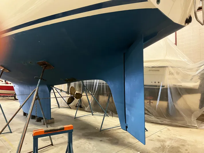 Here Be Dragons Yacht Photos Pics Oyster 46.5 sailboat from 1987 in a workshop, showing hull and propeller.