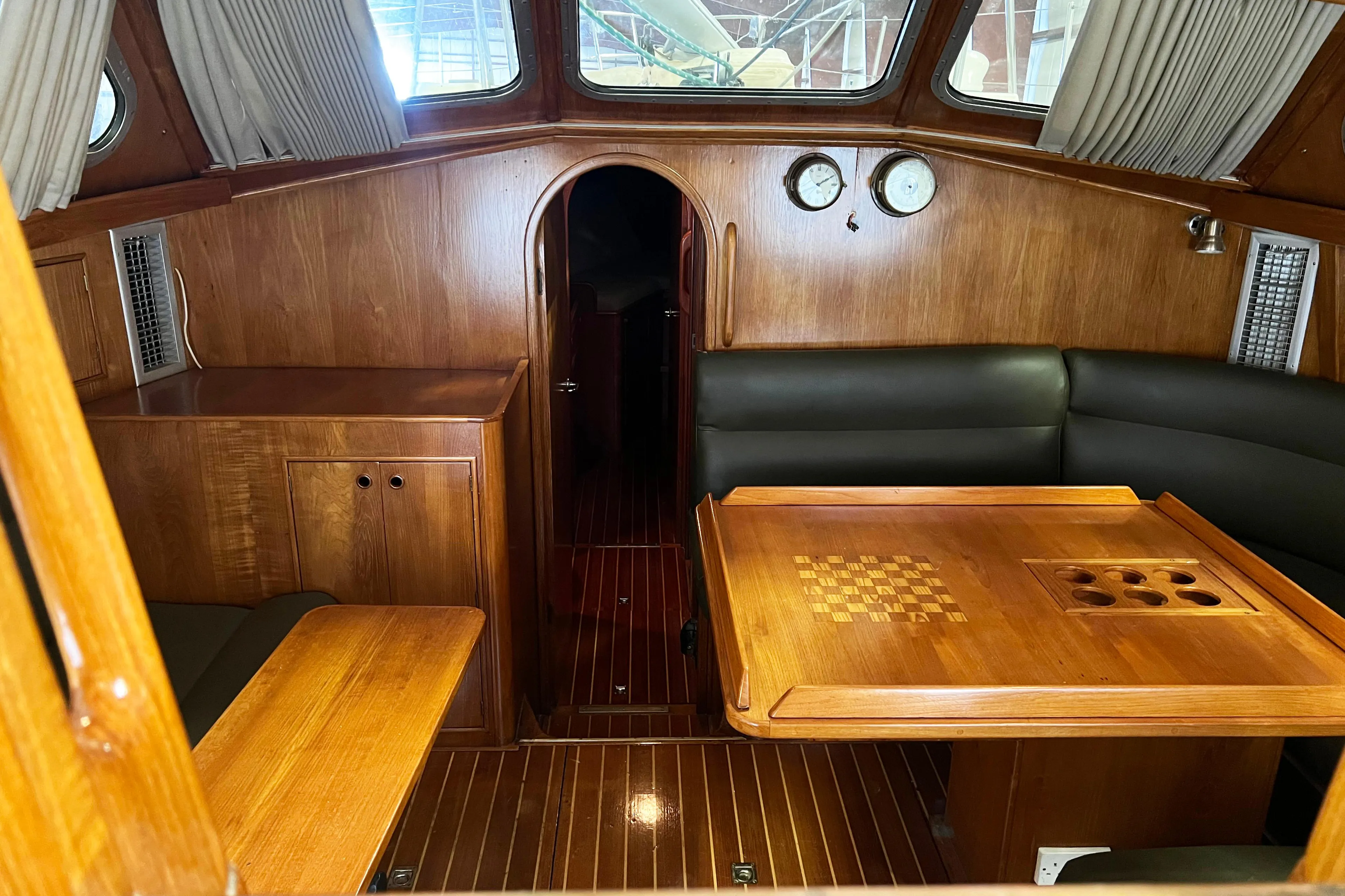Interior of 1987 Oyster 46.5 yacht with wooden furnishings and seating area.
