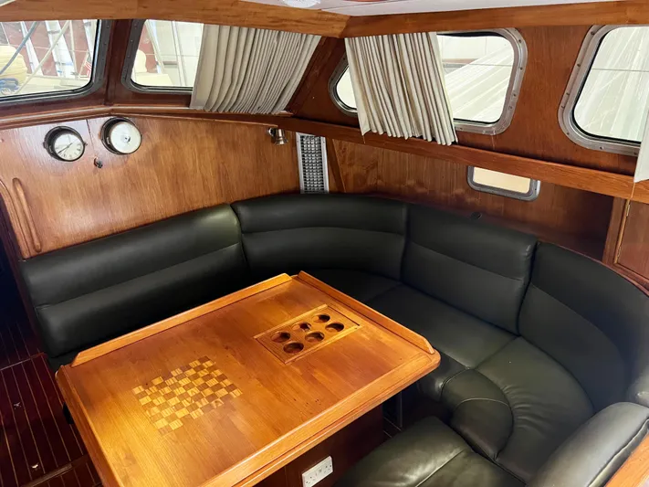 Here Be Dragons Yacht Photos Pics Interior of 1987 Oyster 46.5 yacht with wood paneling and leather seating.