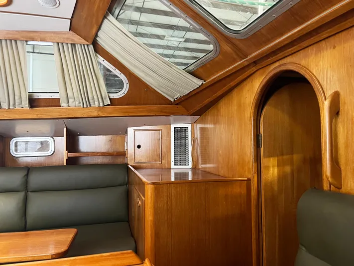 Here Be Dragons Yacht Photos Pics Interior of 1987 Oyster 46.5 yacht with wood paneling and seating.