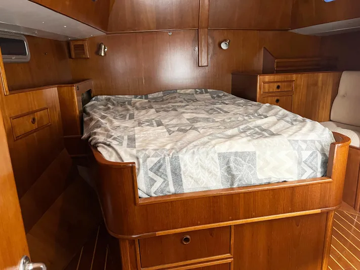 Here Be Dragons Yacht Photos Pics Cozy cabin interior of 1987 Oyster 46.5 yacht with wooden furnishings and bed.