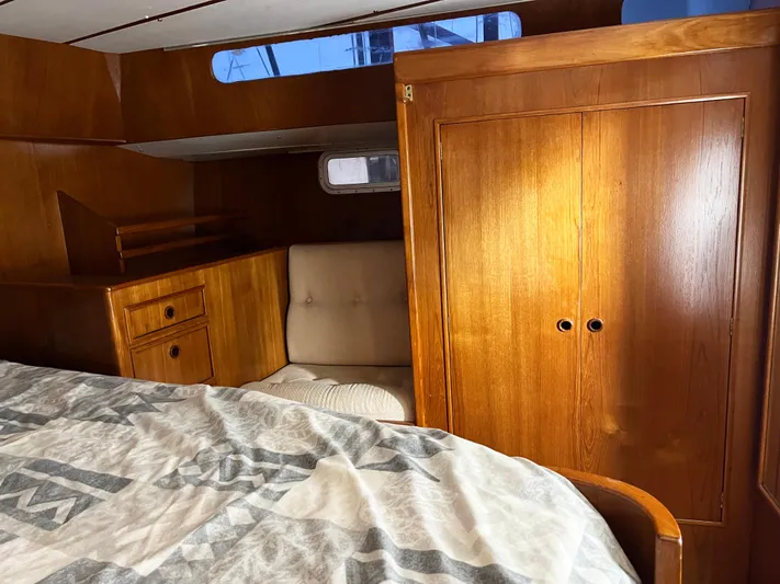 Here Be Dragons Yacht Photos Pics Interior of 1987 Oyster 46.5 yacht with wooden cabinetry and cozy seating area.