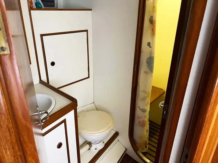 Here Be Dragons Yacht Photos Pics 1987 Oyster 46.5 yacht bathroom with wooden trim and compact design.