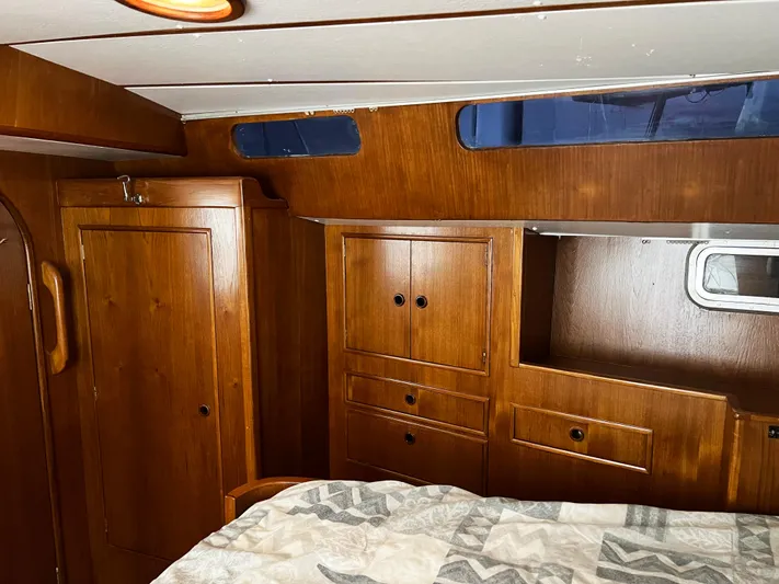 Here Be Dragons Yacht Photos Pics Cozy wooden cabin interior of 1987 Oyster 46.5 yacht with storage cabinets.