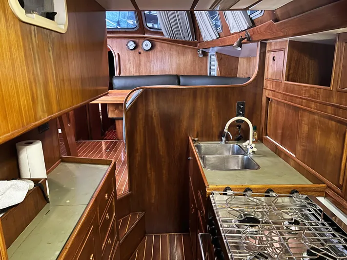Here Be Dragons Yacht Photos Pics Interior of 1987 Oyster 46.5 yacht with wooden cabinetry and modern kitchen amenities.