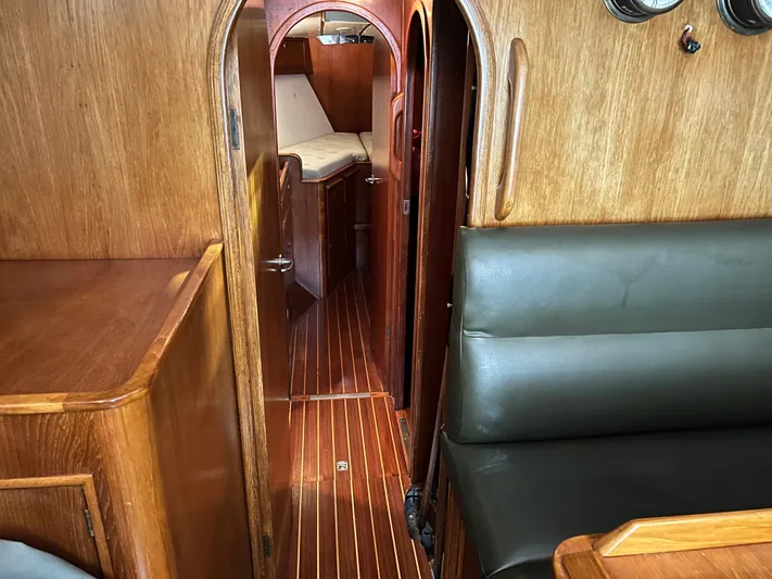 Here Be Dragons Yacht Photos Pics Interior of 1987 Oyster 46.5 yacht with wooden finish and cozy seating area.