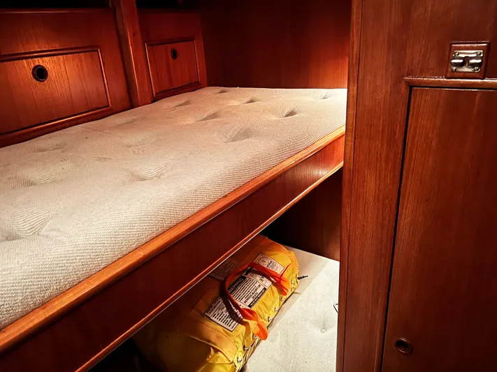 Here Be Dragons Yacht Photos Pics Cozy cabin interior of 1987 Oyster 46.5 yacht with wooden finish and storage space.