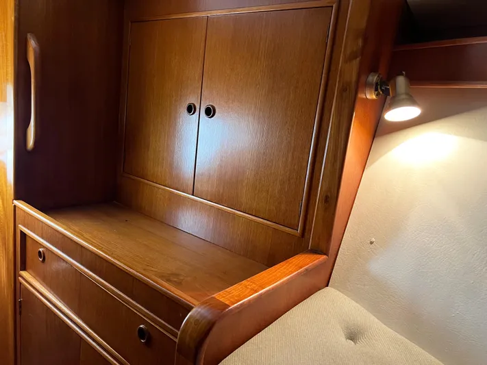 Here Be Dragons Yacht Photos Pics Wooden interior of 1987 Oyster 46.5 yacht with cabinet and ambient lighting.