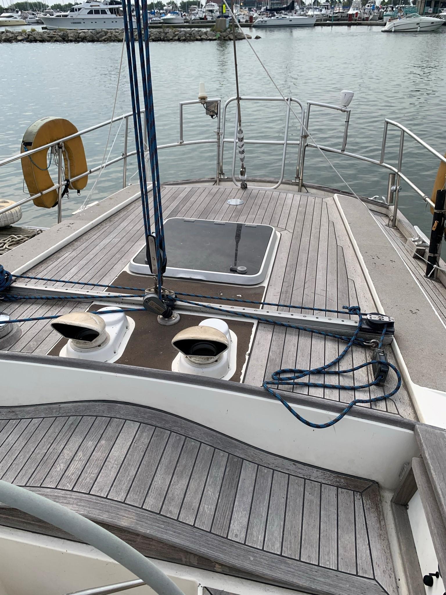 1987 Oyster 46.5 sailboat deck with wooden finish, docked at marina.
