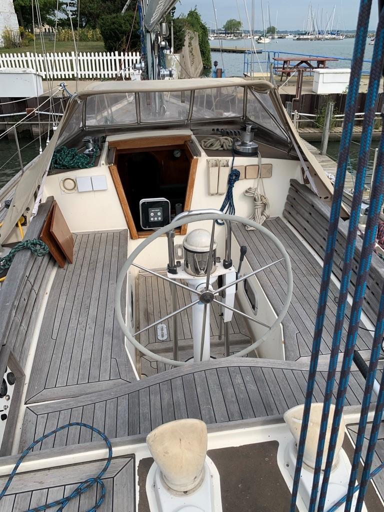 1987 Oyster 46.5 sailboat cockpit with wooden deck and steering wheel.