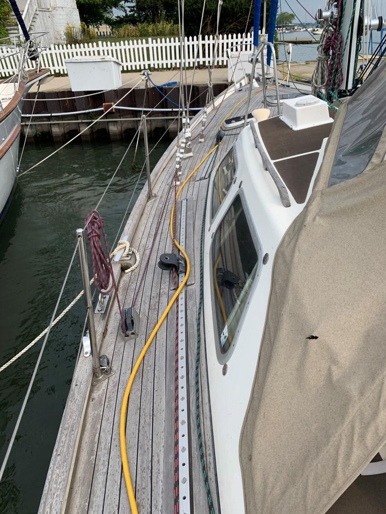1987 Oyster 46.5 sailboat docked, featuring teak deck and cabin details.