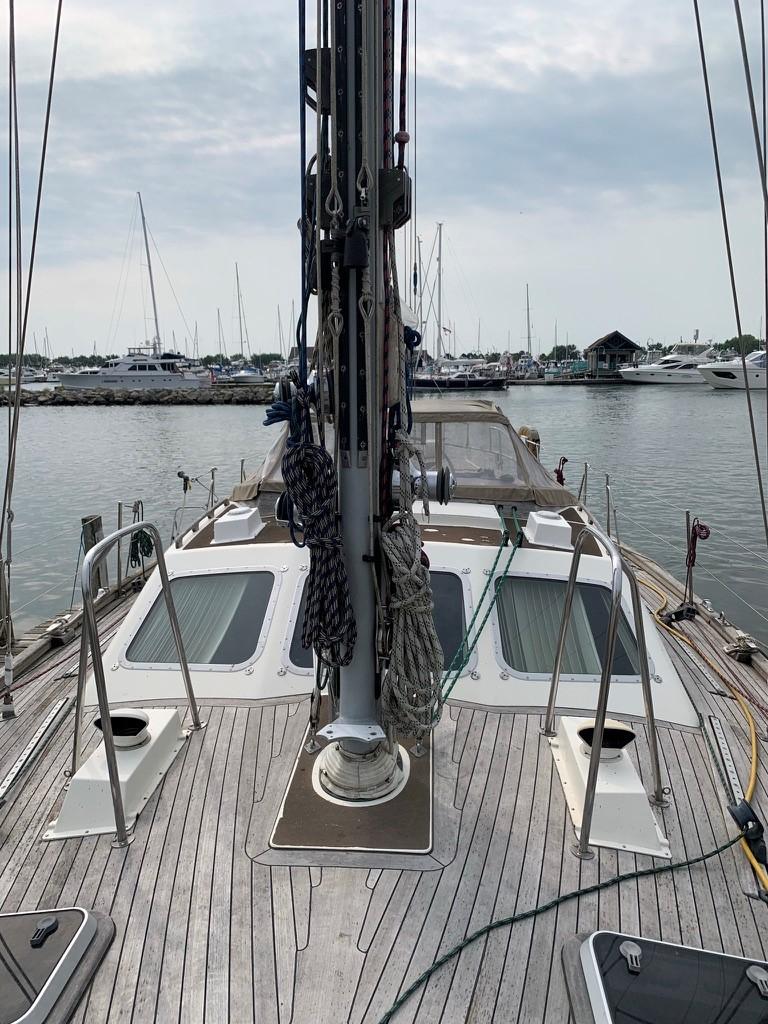 1987 Oyster 46.5 sailboat deck with marina view, showcasing rigging and teak finish.