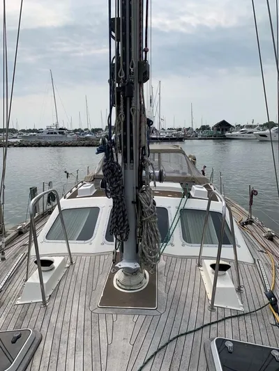 Here Be Dragons Yacht Photos Pics 1987 Oyster 46.5 sailboat deck with marina view, showcasing rigging and teak finish.