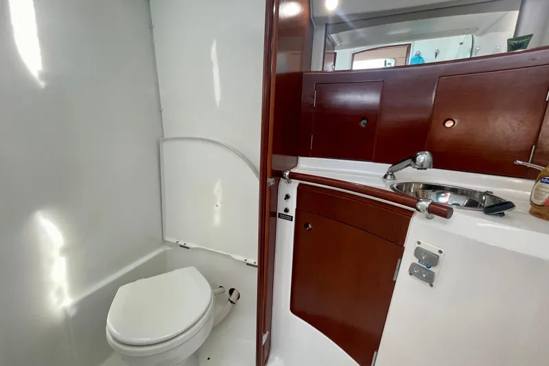 Caravan Yacht Photos Pics Beneteau First 47.7 2003 yacht bathroom with wooden cabinetry and compact design.