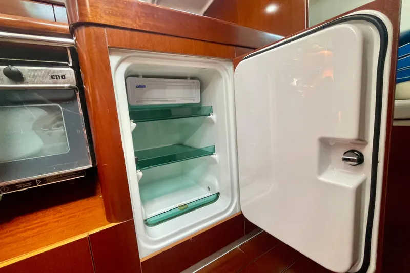 Caravan Yacht Photos Pics Open refrigerator in 2003 Beneteau First 47.7 yacht kitchen, showcasing interior shelves.
