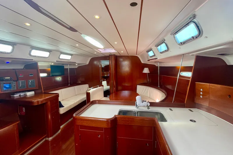 Caravan Yacht Photos Pics Luxurious interior of 2003 Beneteau First 47.7 yacht with elegant wood finish and seating.