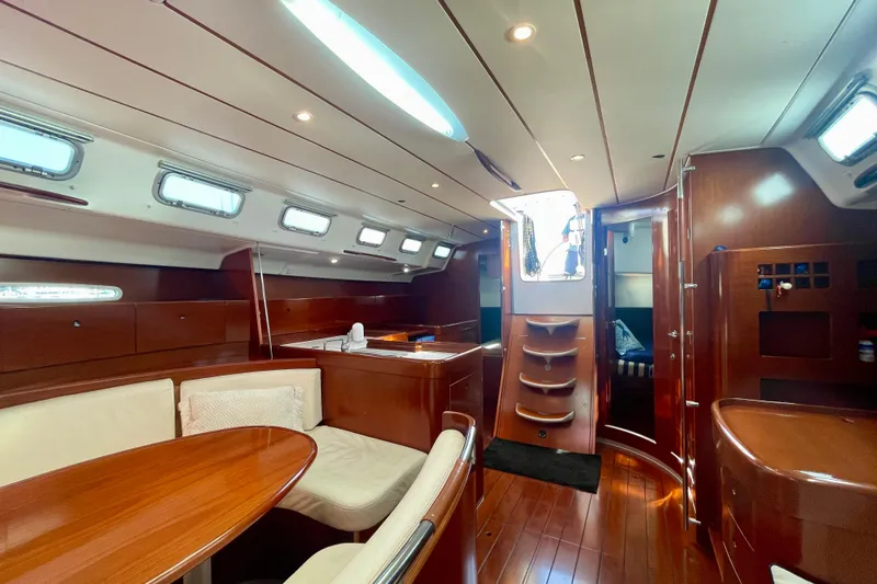 Caravan Yacht Photos Pics Luxurious interior of 2003 Beneteau First 47.7 sailboat with elegant wood finish.