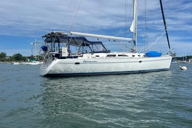 Optimistic Yacht Photos Pics 2003 Catalina 470 Sloop with wing keel anchored on calm water under blue sky.