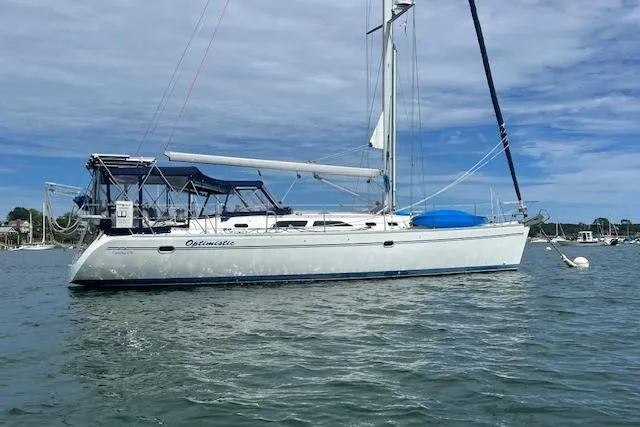Optimistic Yacht Photos Pics 2003 Catalina 470 Sloop with Wing Keel sailing on calm waters under a cloudy sky.