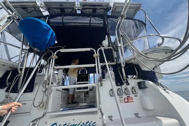 Optimistic Yacht Photos Pics 2003 Catalina 470 Sloop with Wing Keel, featuring a spacious cockpit and blue canopy.