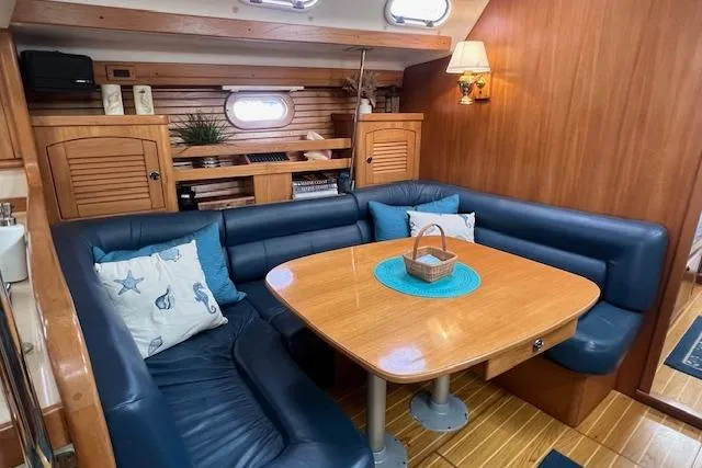 Optimistic Yacht Photos Pics Interior of 2003 Catalina 470 Sloop, featuring a cozy dining area with blue seating.
