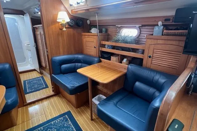Optimistic Yacht Photos Pics Interior of 2003 Catalina 470 Sloop, featuring cozy seating and wooden cabinetry.