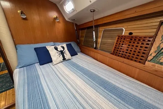 Optimistic Yacht Photos Pics Cozy cabin interior of 2003 Catalina 470 Sloop with striped bedding and nautical decor.