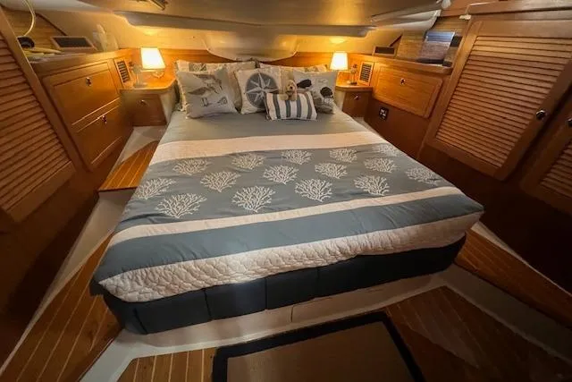 Optimistic Yacht Photos Pics Cozy cabin interior of 2003 Catalina 470 Sloop with wing keel, featuring a comfortable bed.