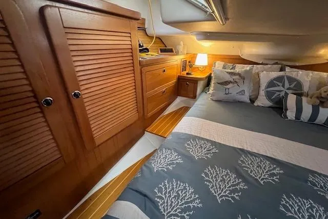 Optimistic Yacht Photos Pics Cozy cabin interior of 2003 Catalina 470 Sloop with Wing Keel, featuring wooden cabinetry and nautical decor.