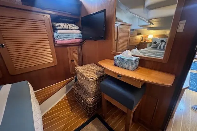 Optimistic Yacht Photos Pics Cozy interior of 2003 Catalina 470 Sloop, featuring wooden cabinetry and a small desk area.