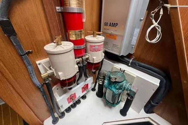 Optimistic Yacht Photos Pics Engine room of 2003 Catalina 470 Sloop with wing keel, featuring fuel filters and electrical panel.