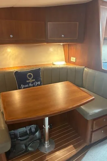  Yacht Photos Pics Cozy dining area in 2006 Topaz 40 Express yacht with wooden table and cushioned seating.