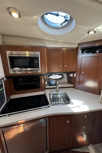  Yacht Photos Pics 2018 Crownline 350 SY yacht kitchen with modern appliances and wood cabinetry.