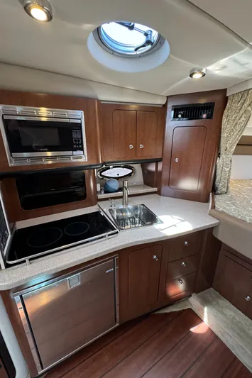  Yacht Photos Pics 2018 Crownline 350 SY yacht kitchen with modern appliances and wood cabinetry.